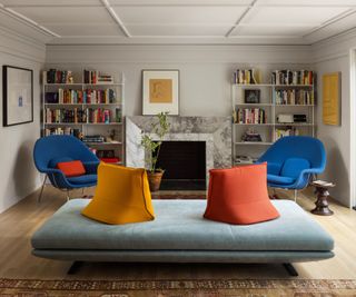 family living room with gray ottoman sofa and bright cushions with bright blue armchairs