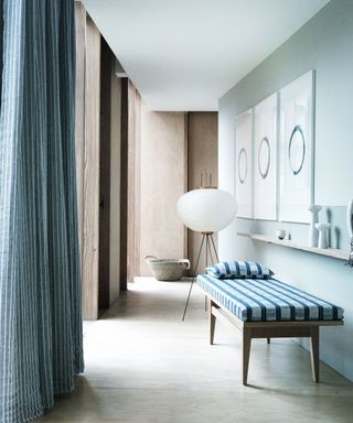hallway with elegant daybed and blue and white stripe curtain