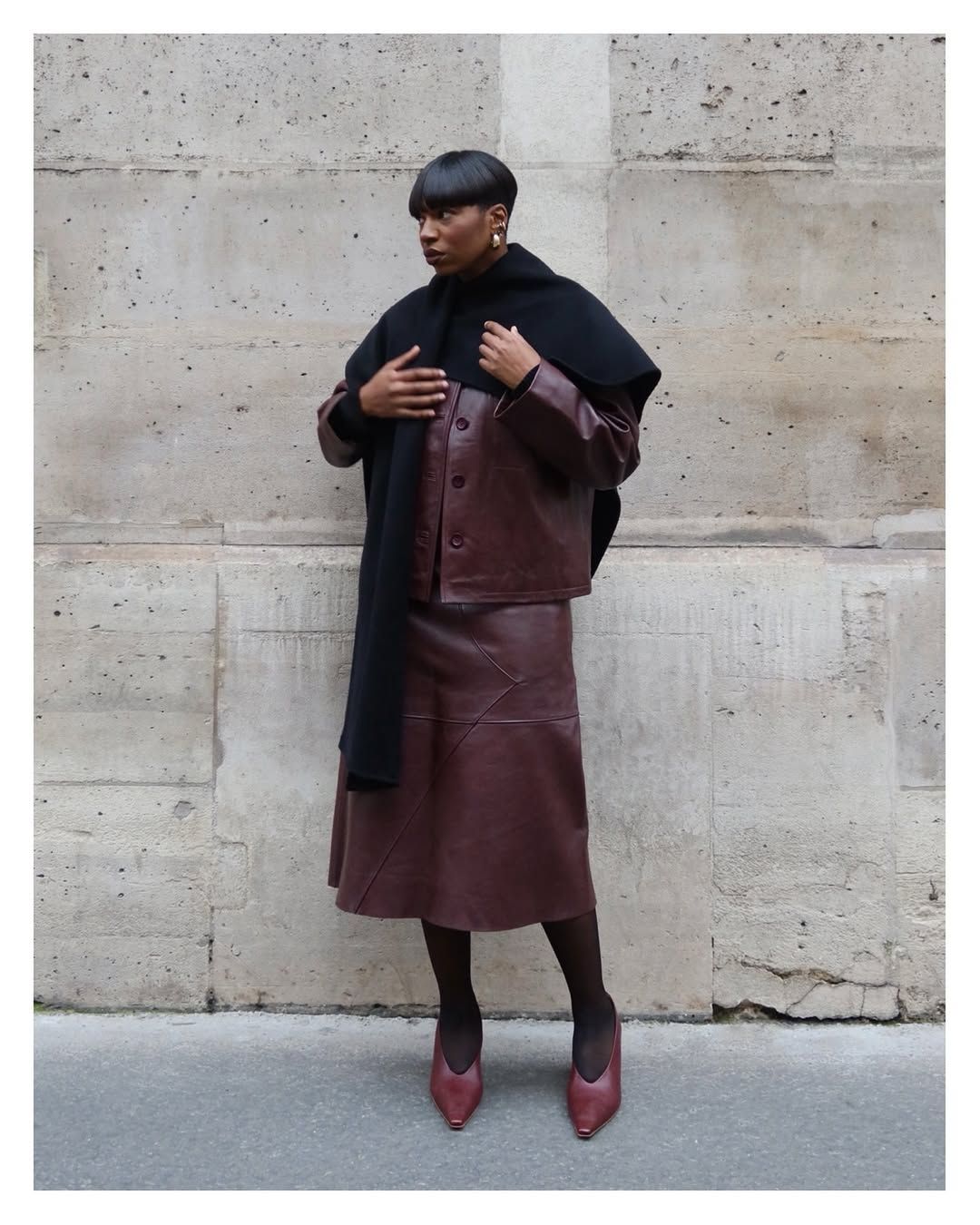 Loïcka Grâce wears a burgundy leather jacket and skirt