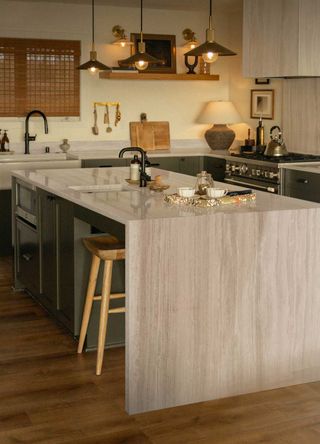 stone kitchen island in a kitchen with two sinks