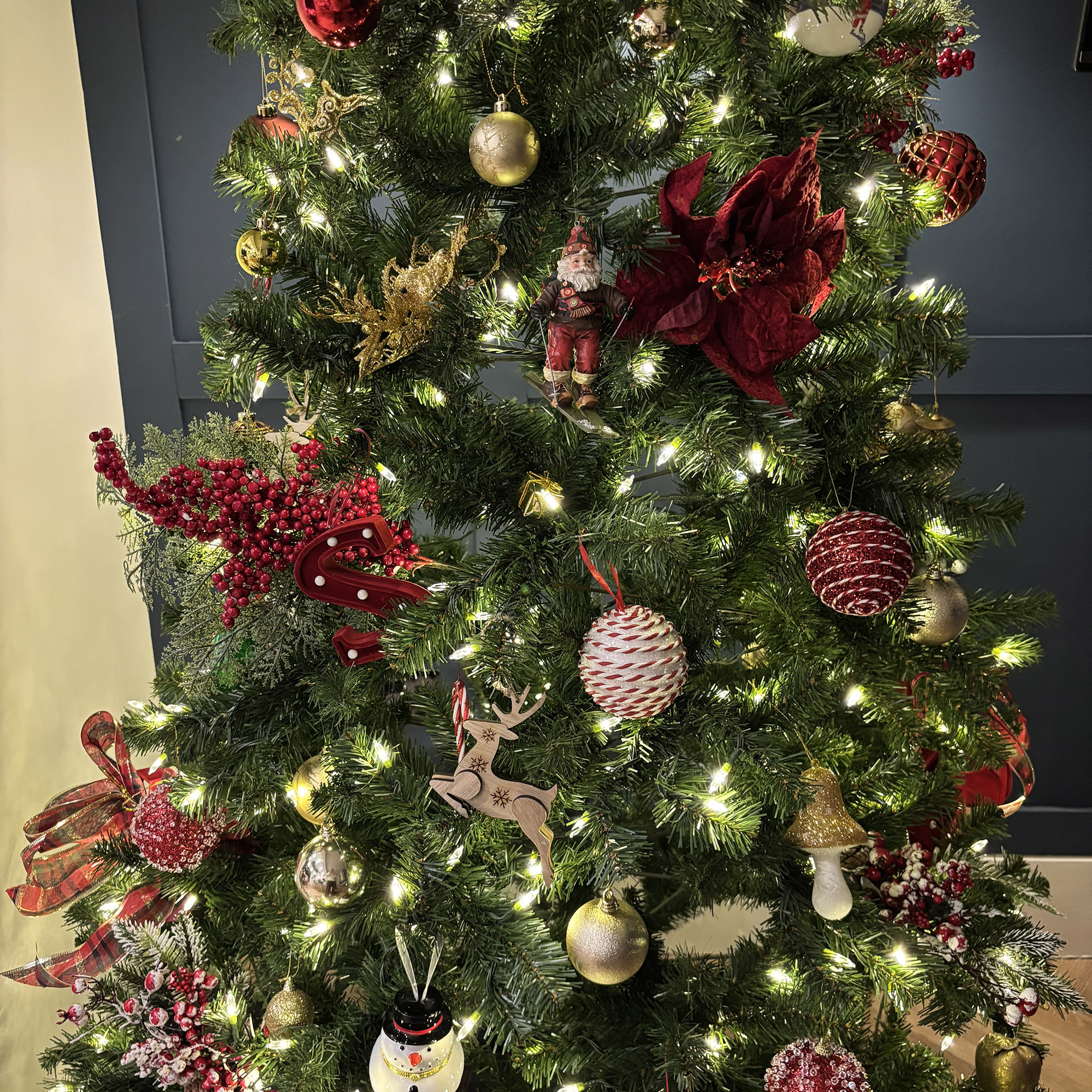 a close up shot of a christmas tree with red and gold decorations