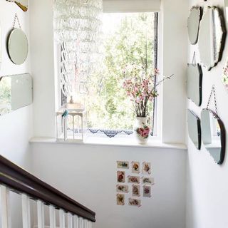 stairway with white wall mirrors on wall and window