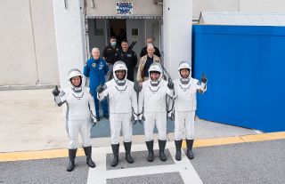 NASA astronauts Shannon Walker, left, Victor Glover, second from left, Michael Hopkins, second from right, and JAXA astronaut Soichi Noguchi, wearing SpaceX spacesuits, pause to pose for a photo at NASA's Kennedy Space Center in Florida.