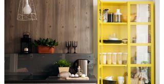 kitchen with bright yellow glass-fronted dresser used a stylish pantry cupboard