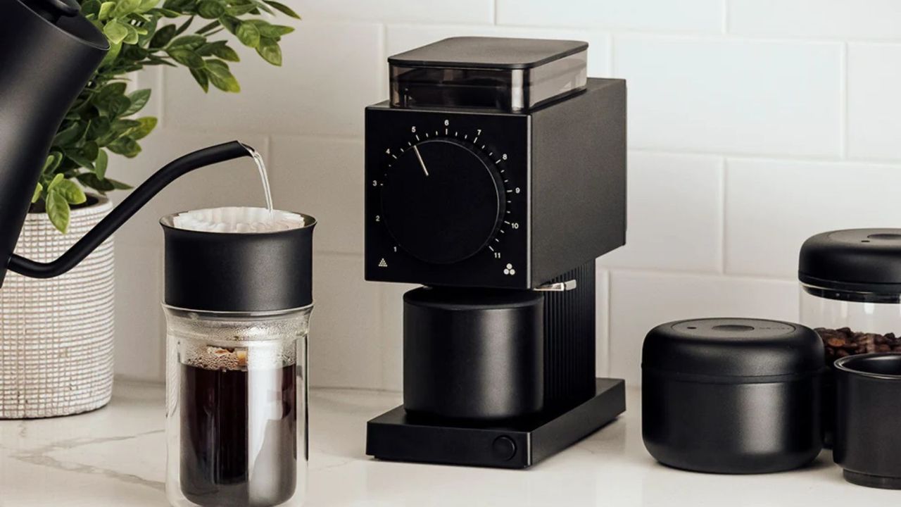 One of the best coffee grinders on the market, the Fellow Ode Coffee Grinder on a countertop with a pour over to the left