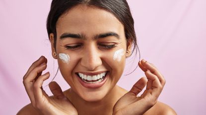 woman applying moisturizer