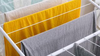 A close up of clothes on a drying rack, spaced apart