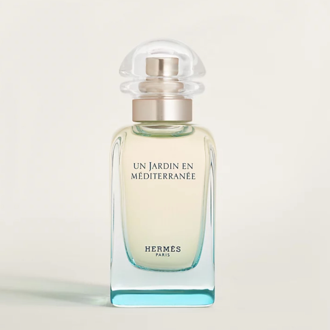 A product shot of the Herm&amp;egrave;s Un Jardin en M&amp;eacute;diterran&amp;eacute;e Eau de Toilette, in blue gradient glass bottle and pictured on a beige background