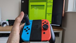 Nintendo Switch Joy-Cons in the hand of an adult featuring Thumb Soldier accessories