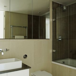 Neutral bathroom with large mirror and wall tiles
