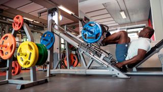 Man performs leg press on weights machine