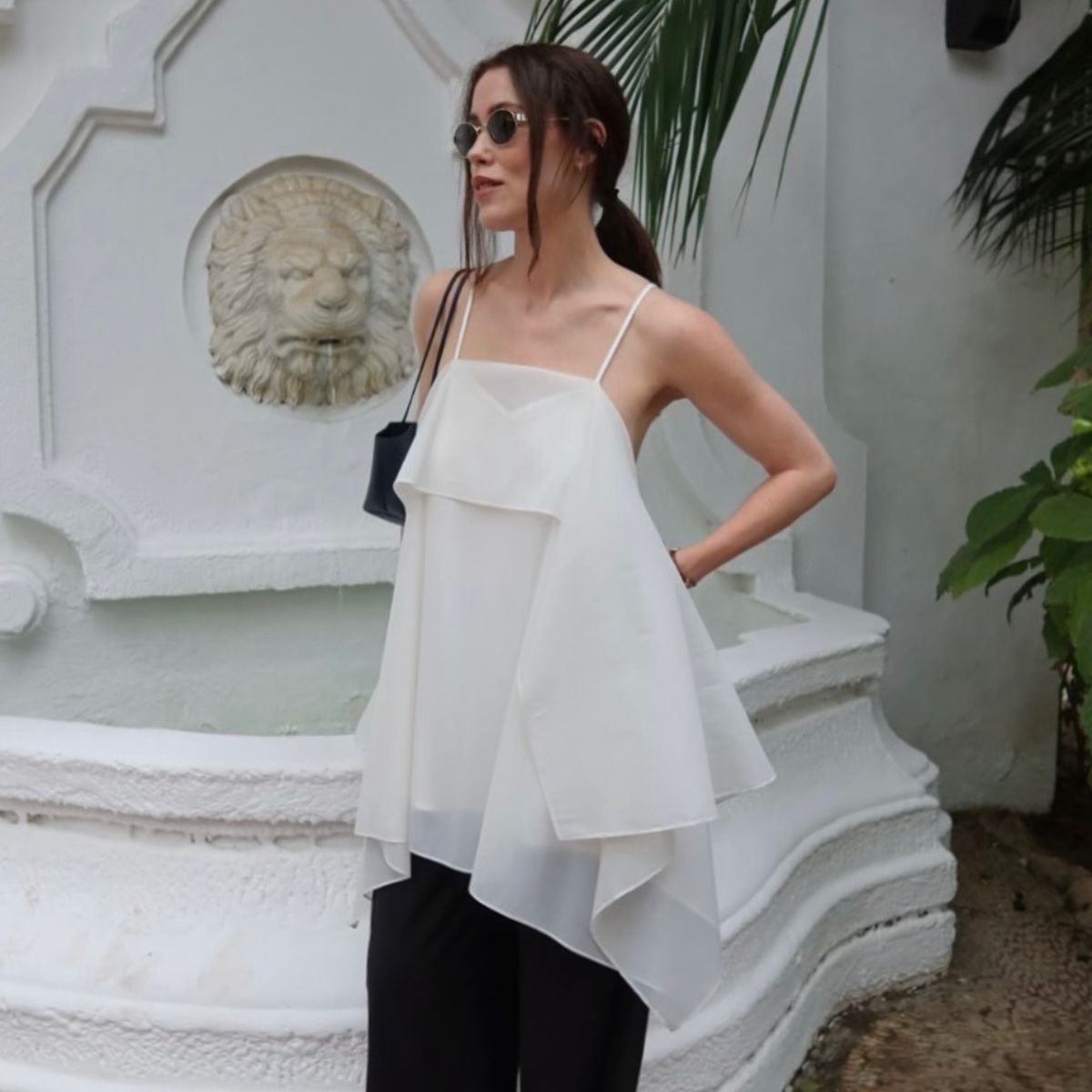 Woman wears white top and black trousers