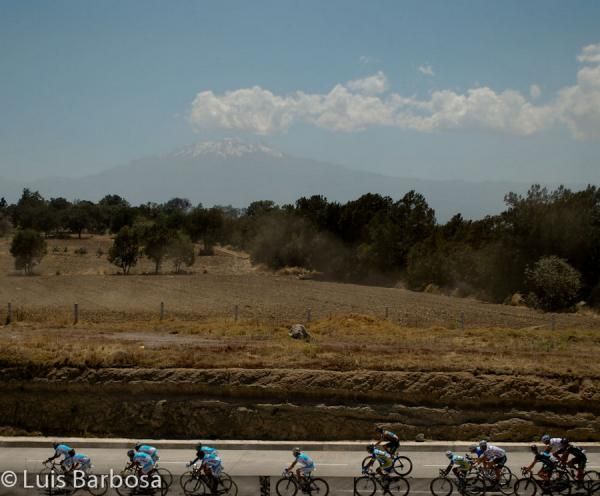 The peloton passes by some open fields