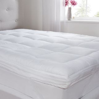 White quilted mattress topper on bed