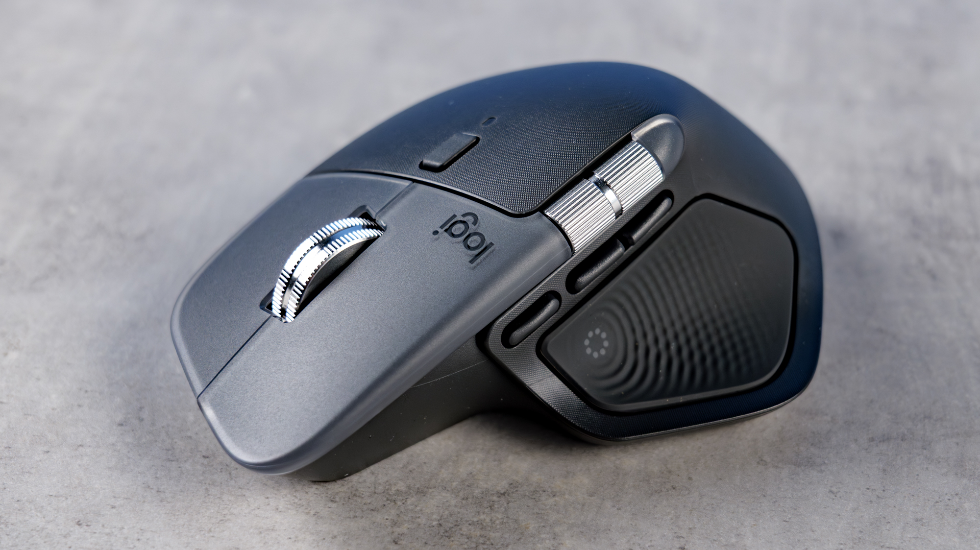 A photo of the Logitech MX Master 4 on a stone surface with a blue background