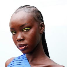 model with bright eye makeup and acne