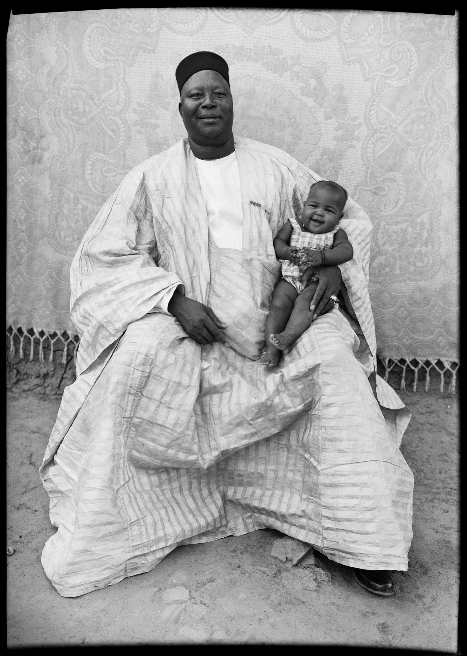 black and white portrait by Seydou Keïta of a person with child on lap