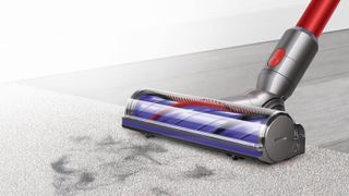 Dyson V7 Advanced cleaning head on a floor with clumps of fur
