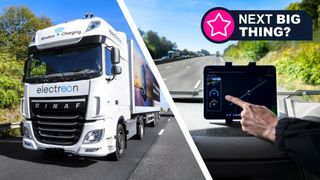 A lorry driving down a highway next to a hand pointing to a tablet mounted on a dashboard