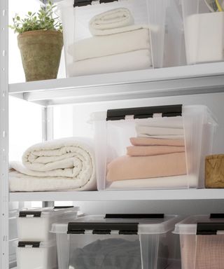 Linen shelves with loose items and clear boxes from ORTHEX at John Lewis