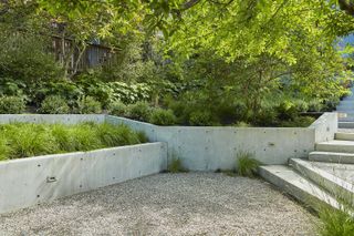 Garden wall with herb bed planted into its top and a gravel garden
