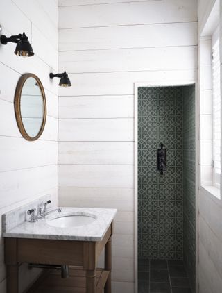 white panelling in small en suite bathroom with dark vanity unit