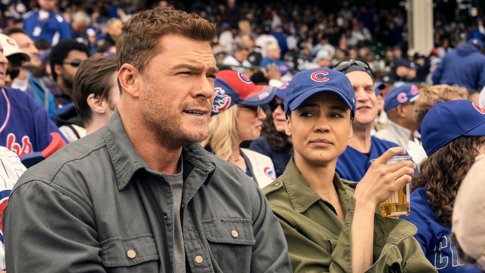 Reacher and Neagley sit in the crowd at a baseball game