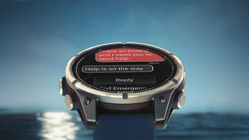 Photoshopped photo of the Garmin Quatix 8 Pro hovering in front of an ocean backdrop, the display showing an SOS conversation stating "help is on the way."
