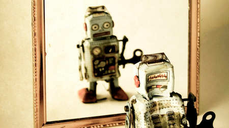 A robot looking at itself in a mirror.
