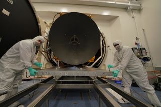 Emirati personnel work with the Hope spacecraft during thermal vacuum testing.