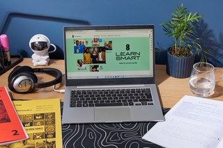 A laptop open on a desk with the LearnSmart hub page showing on the screen