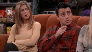 Rachel (Jennifer Aniston) and Joey (Matt LeBlanc) sit on the orange couch in Central Perk on Friends.