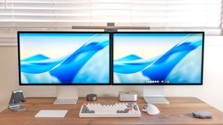 A desk setup with dual Apple Studio Displays side by side
