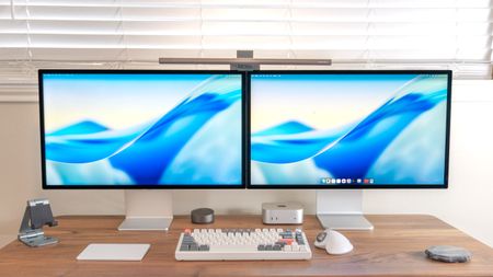 A desk setup with dual Apple Studio Displays side by side