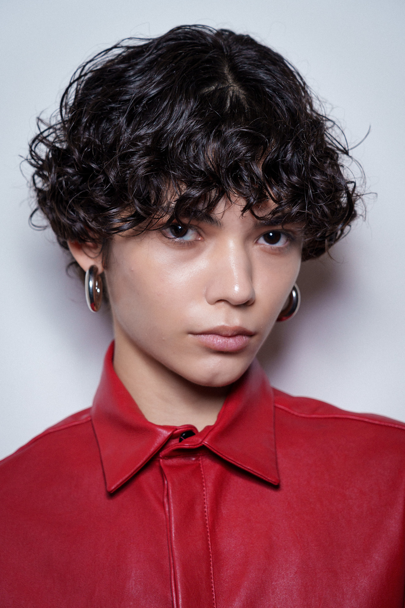 Person with curly bangs with a shaggy pixie.