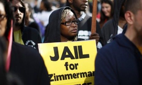 A woman holds a sign calling for the arrest of George Zimmerman during a protest in Los Angeles: More details about Trayvon Martin&amp;#039;s shooter are emerging.