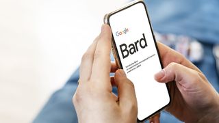 Female hands holding a phone with the Google Bard website on the screen.