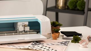 A Cricut Maker on a table with materials