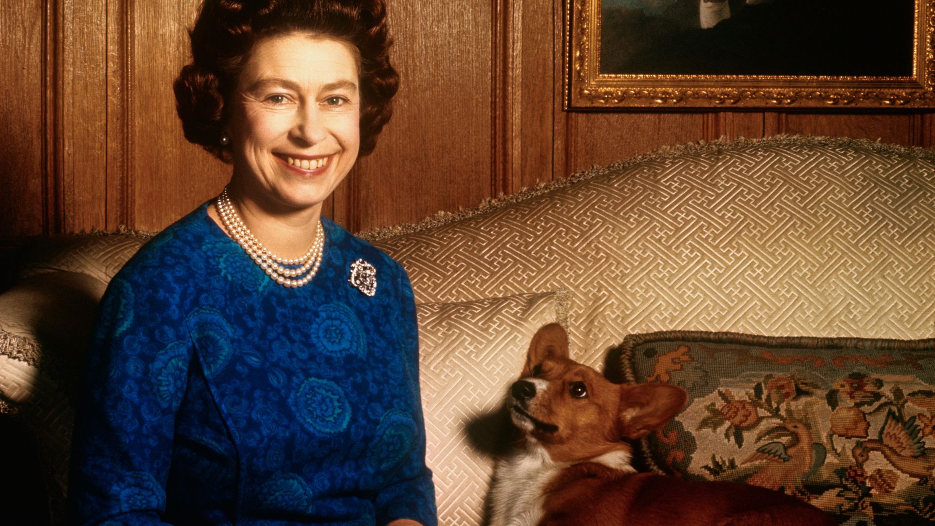 Queen Elizabeth II posing with one of her dogs