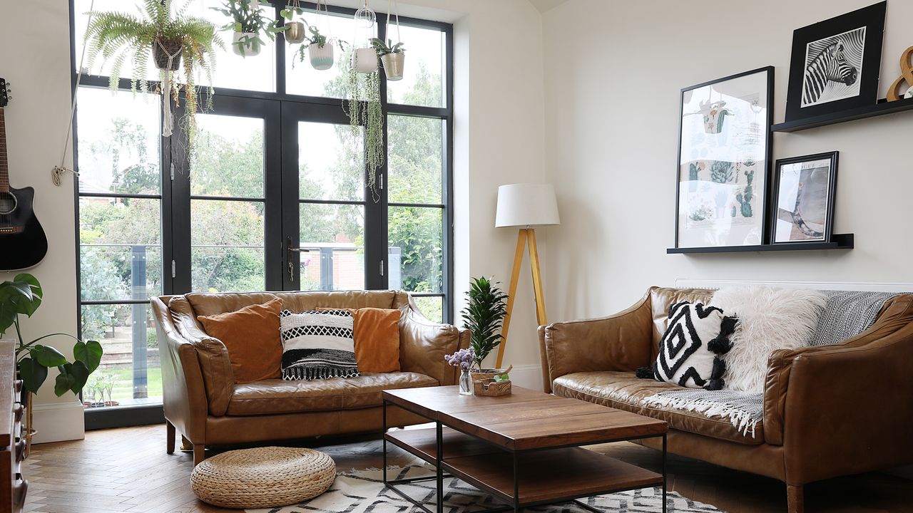 Victorian property revamp with brown leather sofas leading out into the garden via black metal patio doors