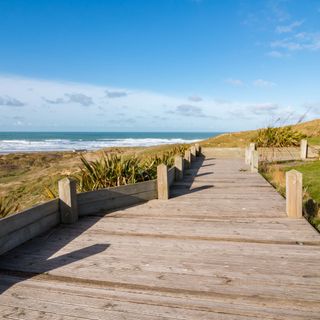 beach with wooden pathway and blue sky