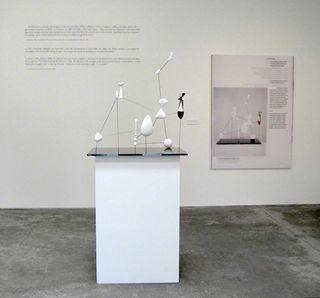 On a table is a constellation of white objects and a poster to the right with information.