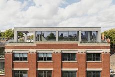 Clerkenwell Rooftop apartment in London, showing minimalist concrete and large openings with terrace and views out to urban views with green