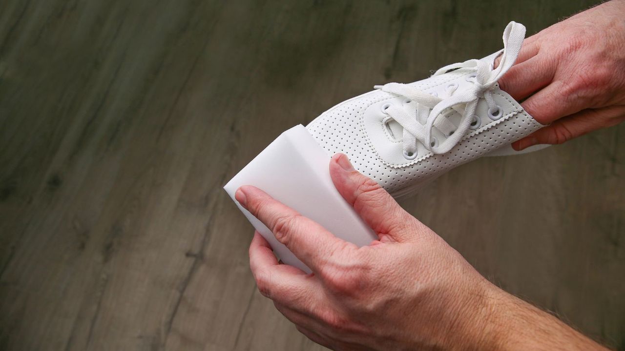 cleaning white shoes with a sponge
