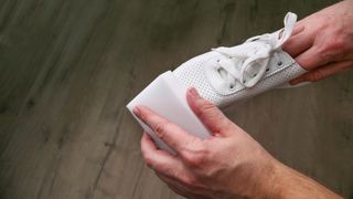 cleaning white shoes with a sponge