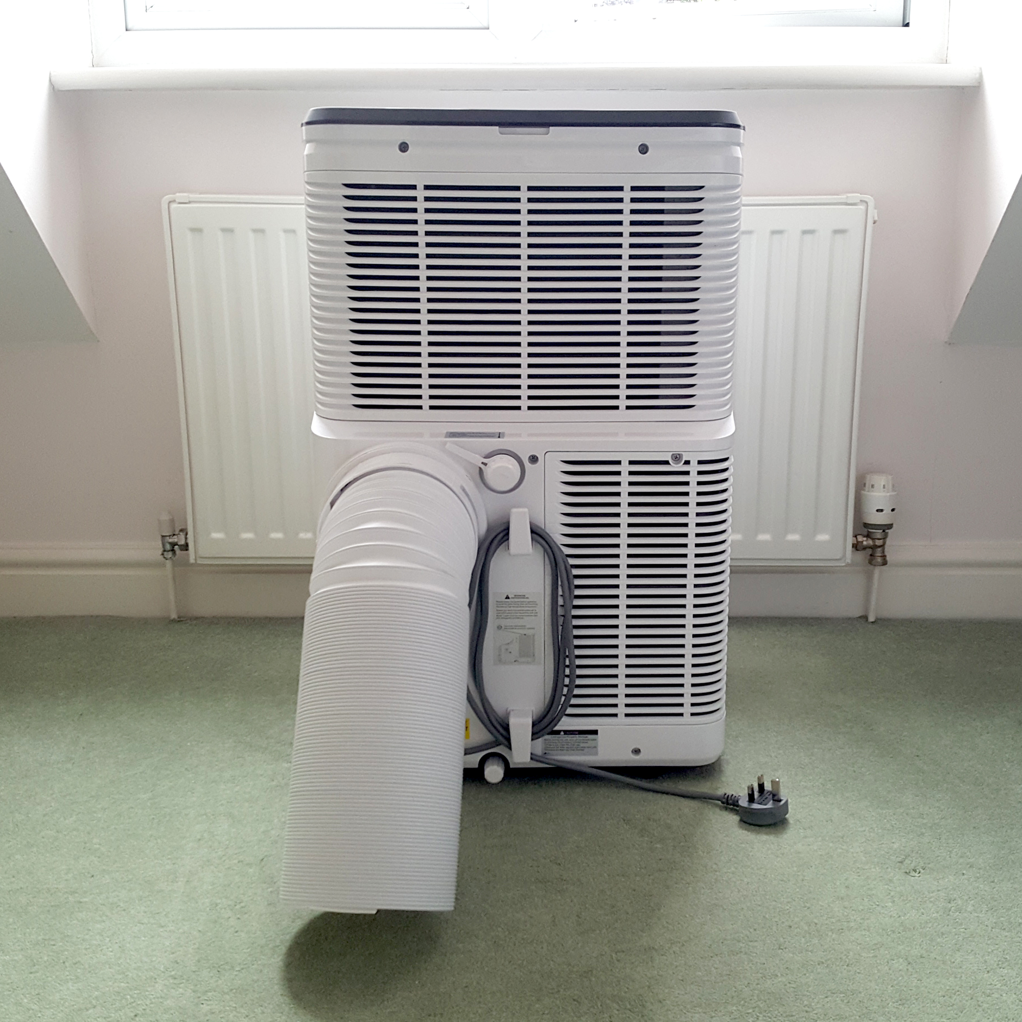 The AEG Comfort 6000 Portable Air Conditioner being tested in a room with green carpet