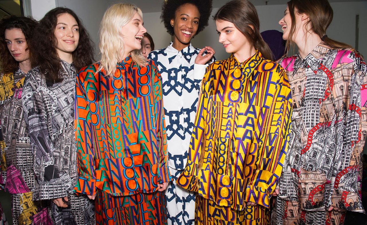 Models wear a range of logo text dresses, in orange, red and blue