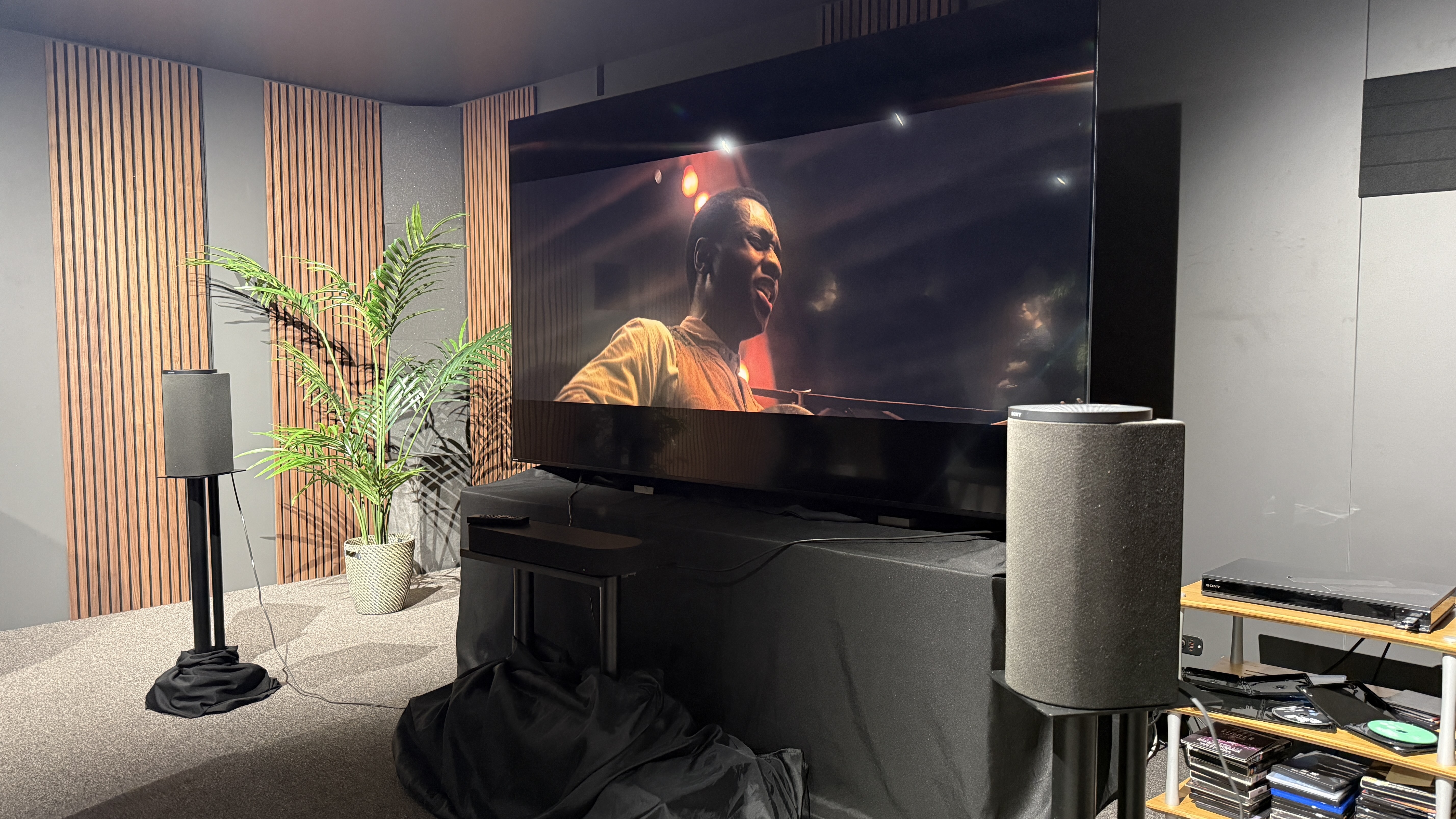 The Sony Bravia Theatre Trio in a listening room, in front of a TV playing Sinners