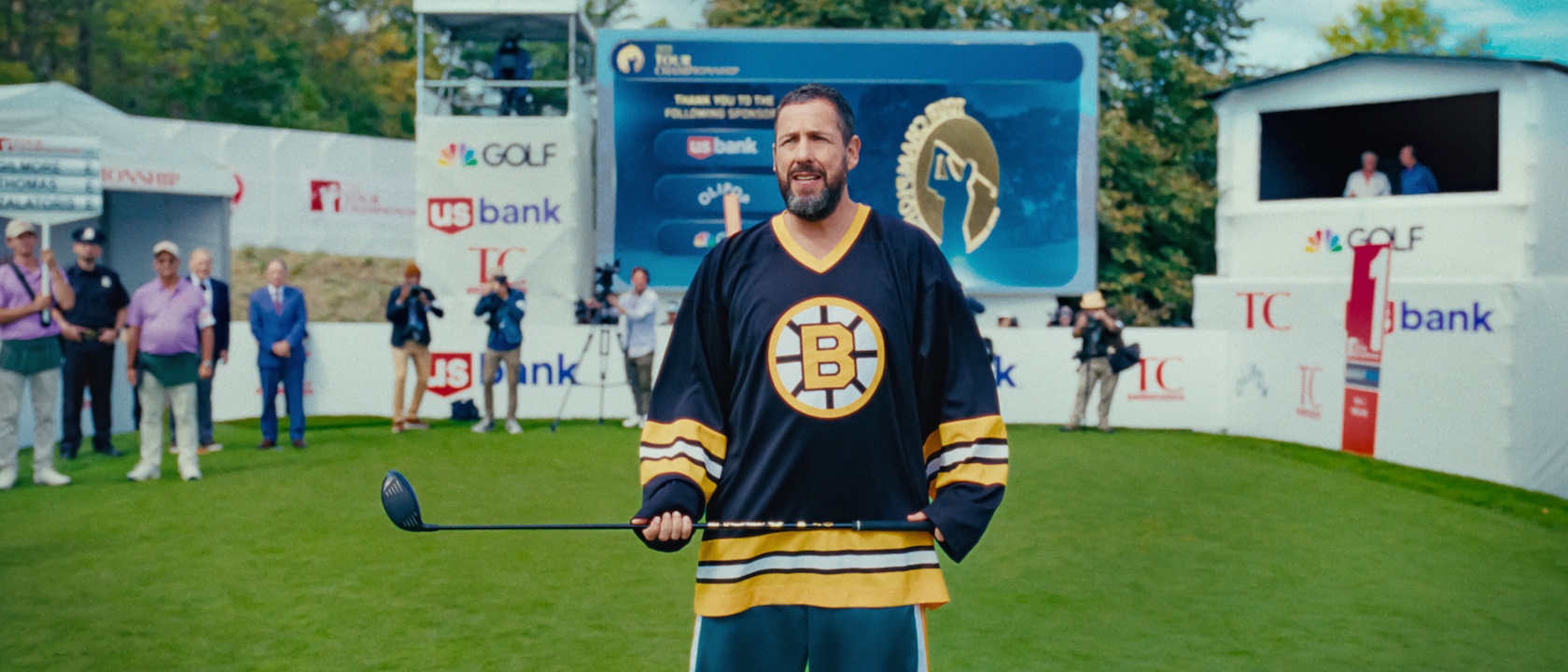 Happy Gilmore holding his club in his signature jersey. 