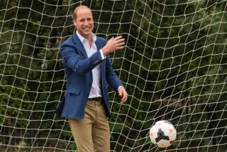 Prince William kicking a soccer ball